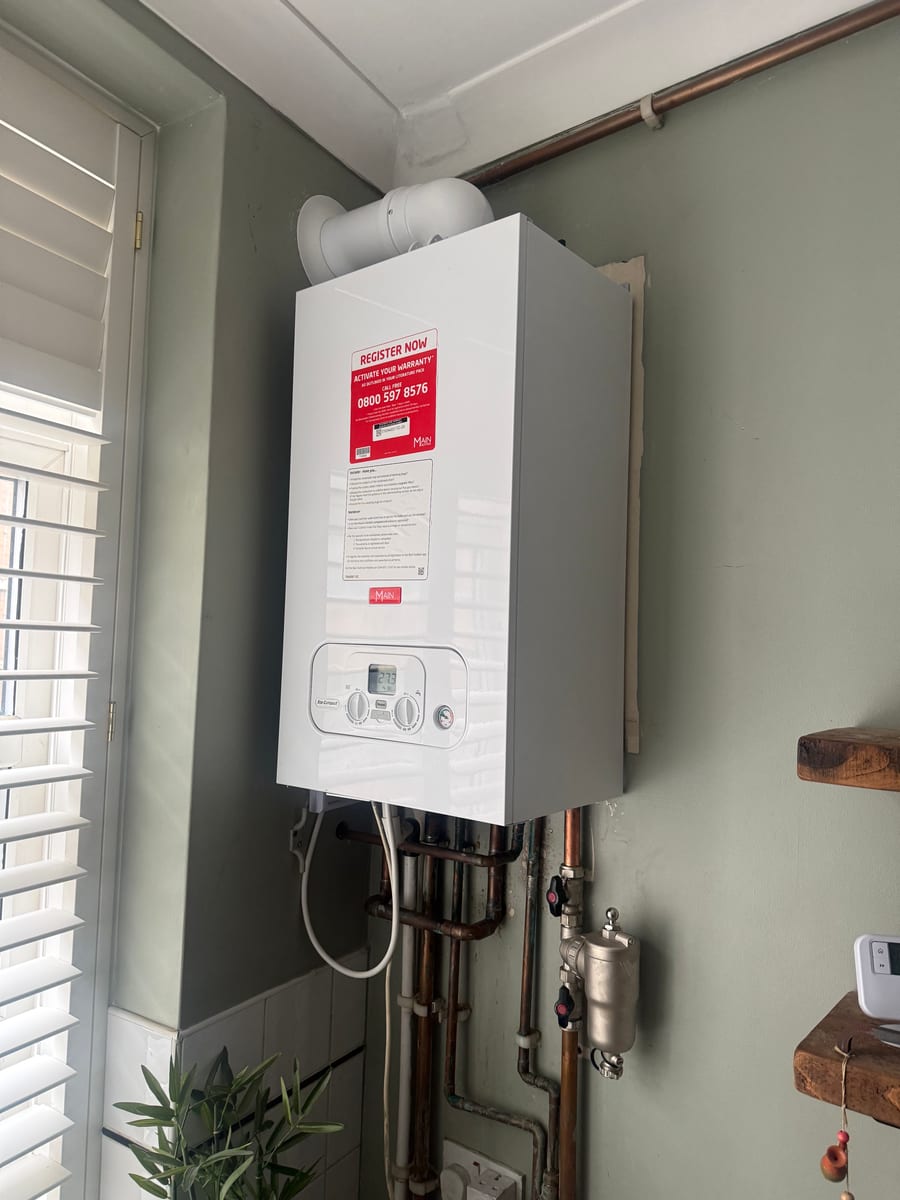 Completed Main Eco Compact combi boiler installation with flue, copper pipework, isolation valves and a magnetic system filter