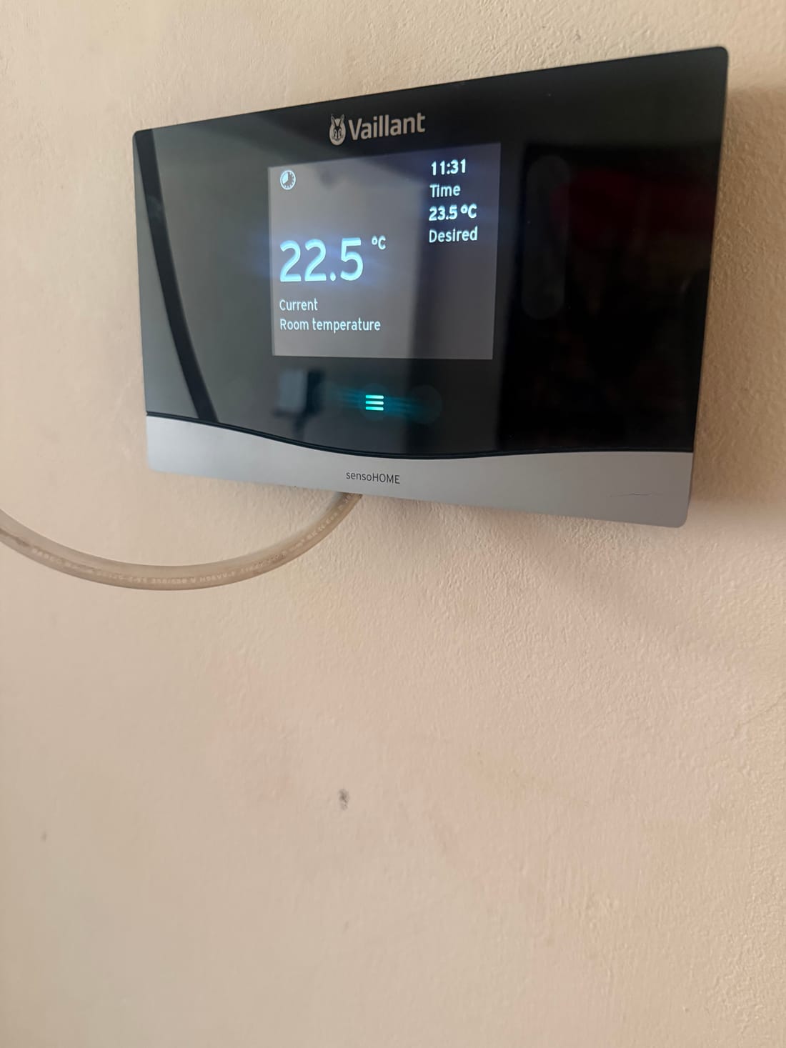 Close view of an installed smart thermostat display reading 22.5 degrees