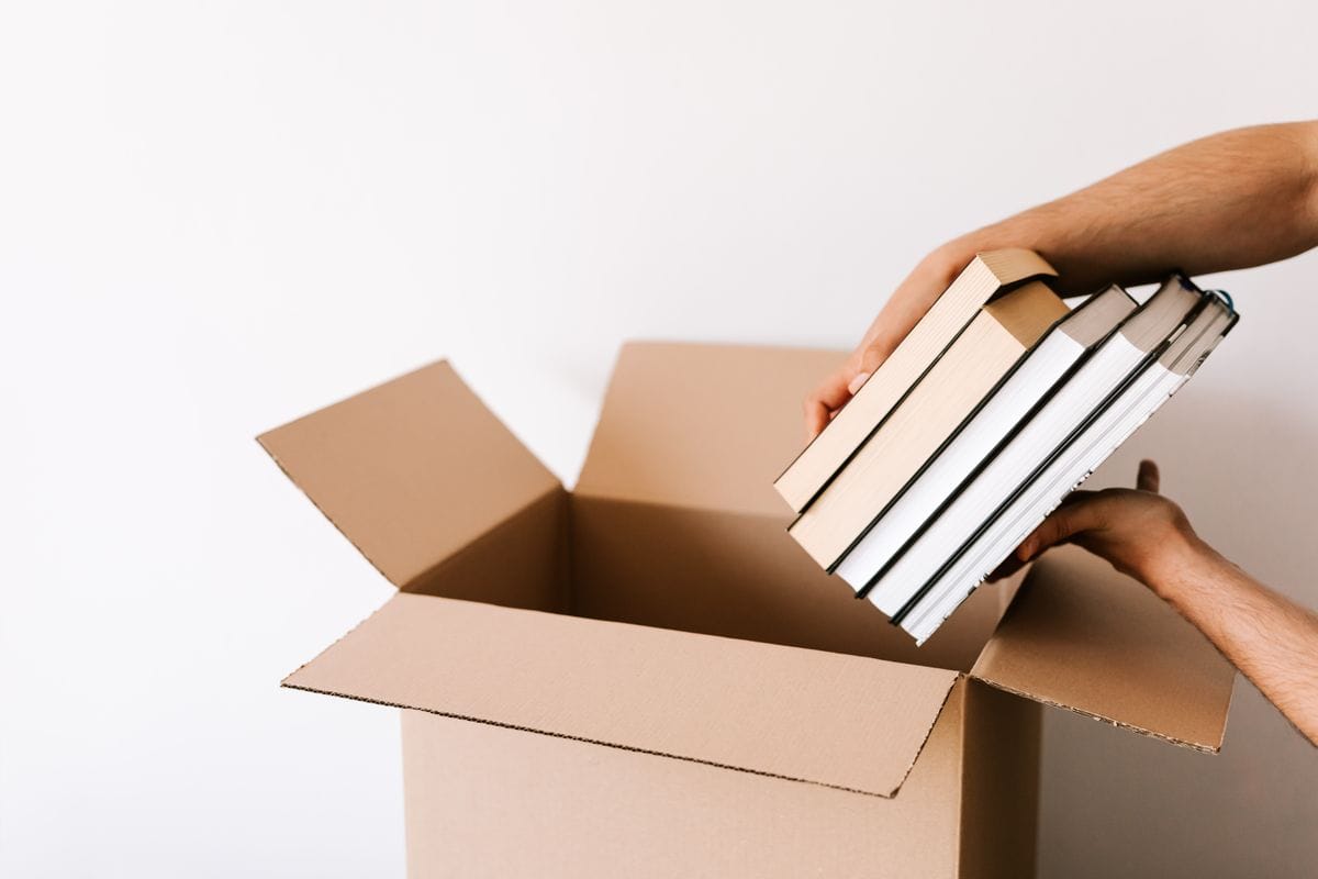 Packing books and belongings into cardboard moving boxes