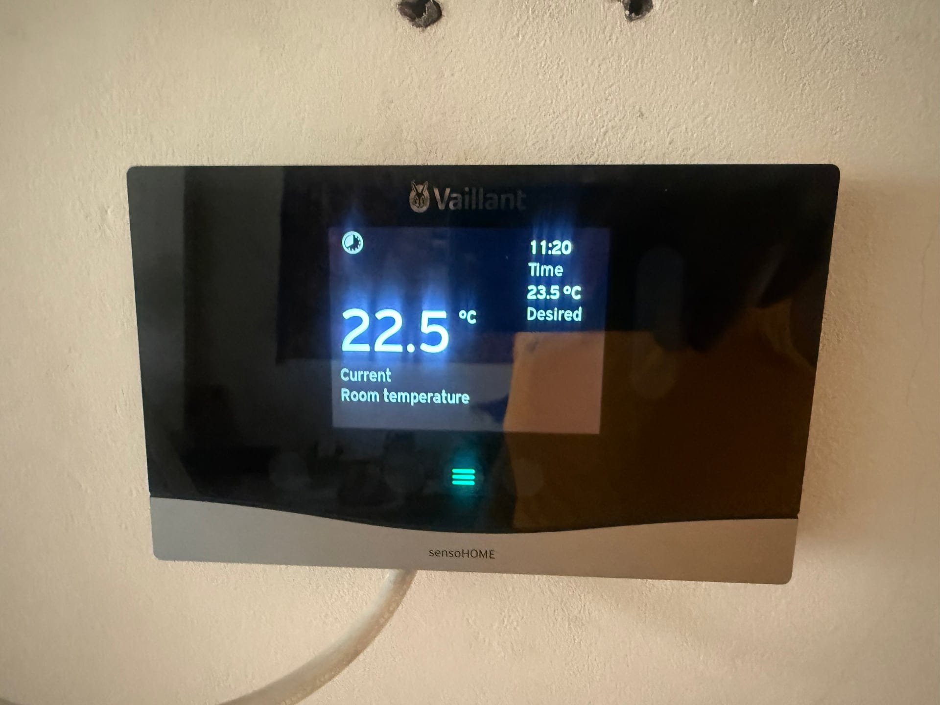 Wall-mounted smart thermostat showing the current room temperature in a London home