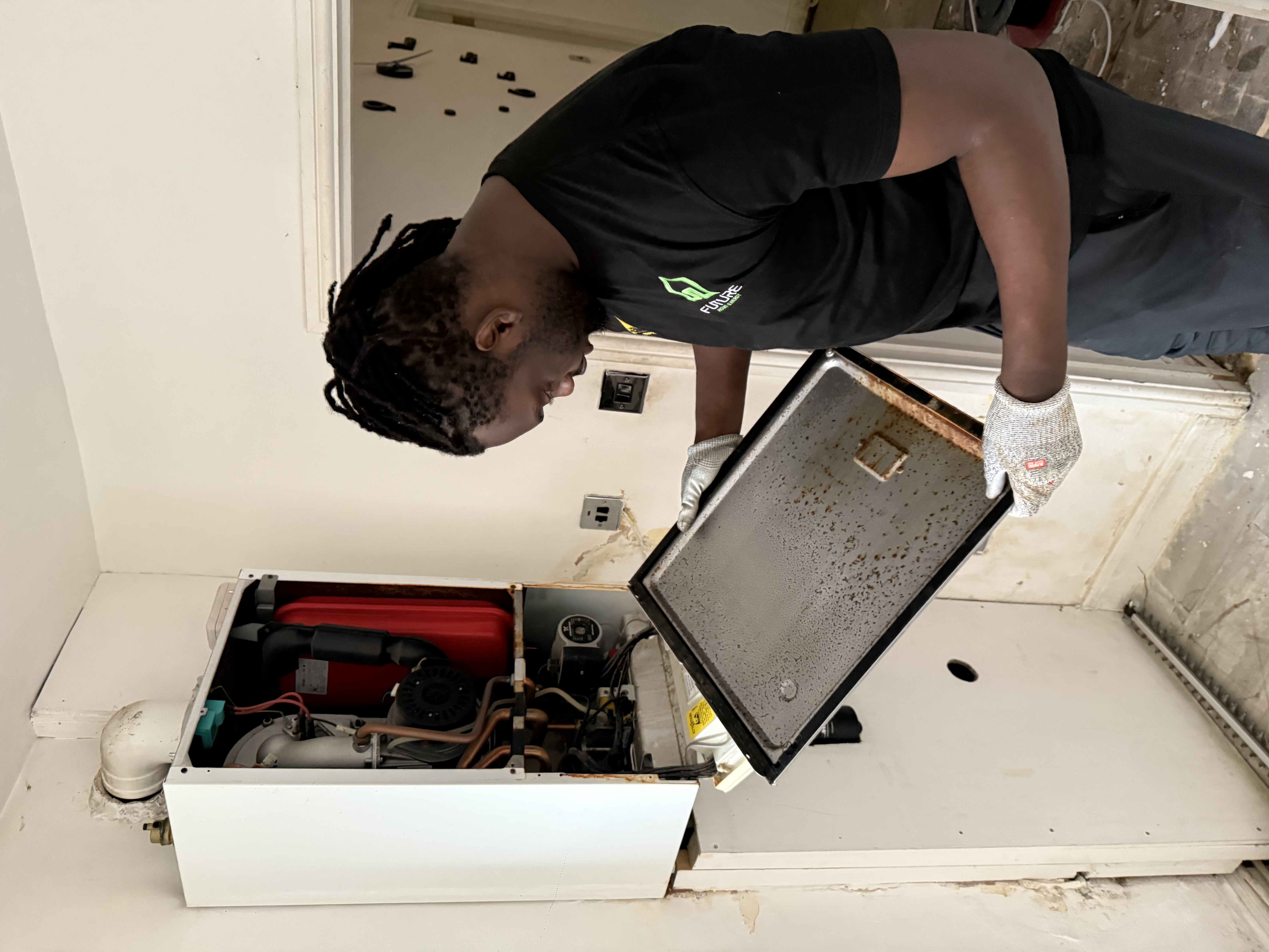 Engineer removing the cover from an open boiler during a service