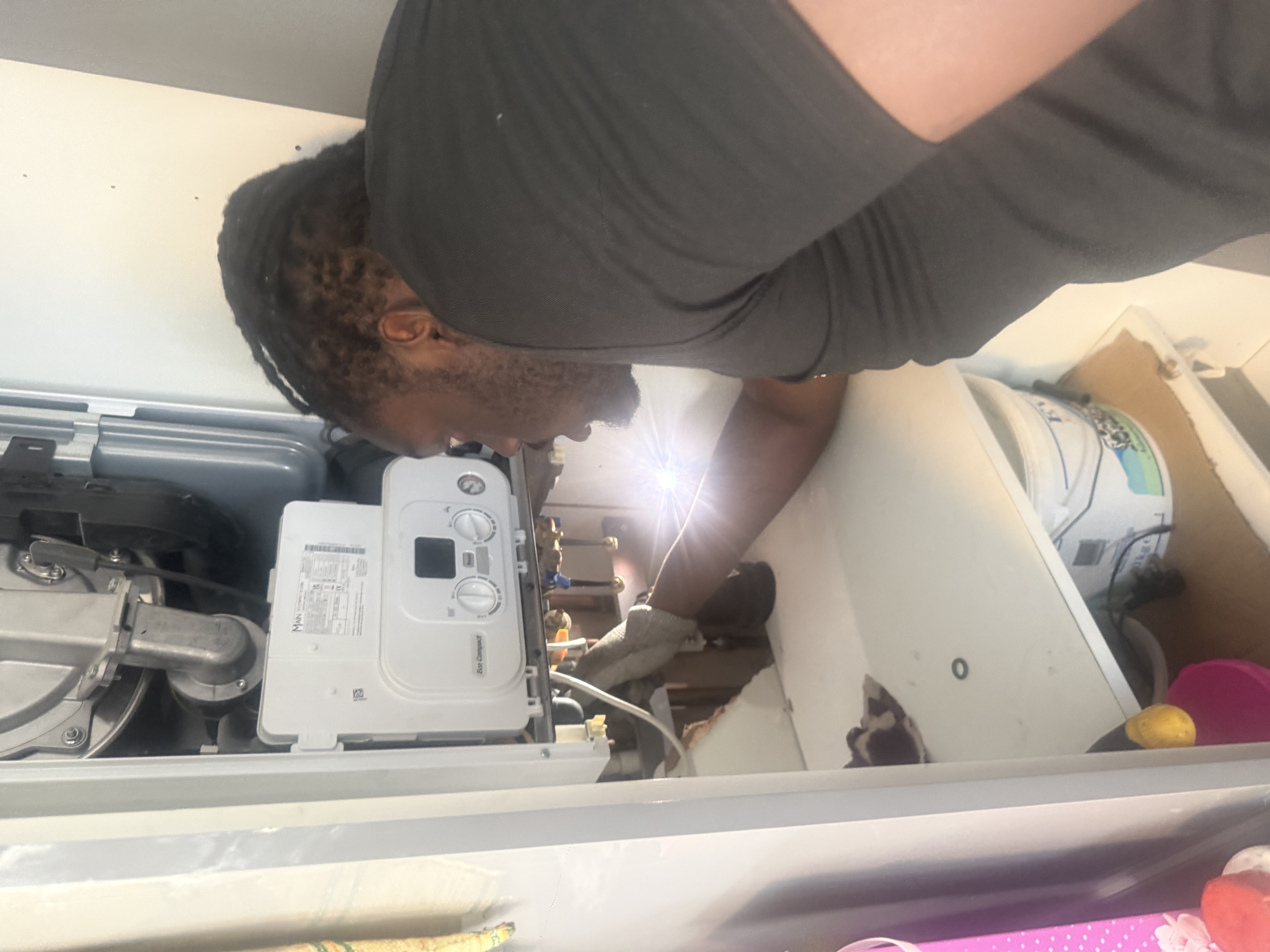Engineer checking the controls and pipework on an open Main Eco Compact boiler