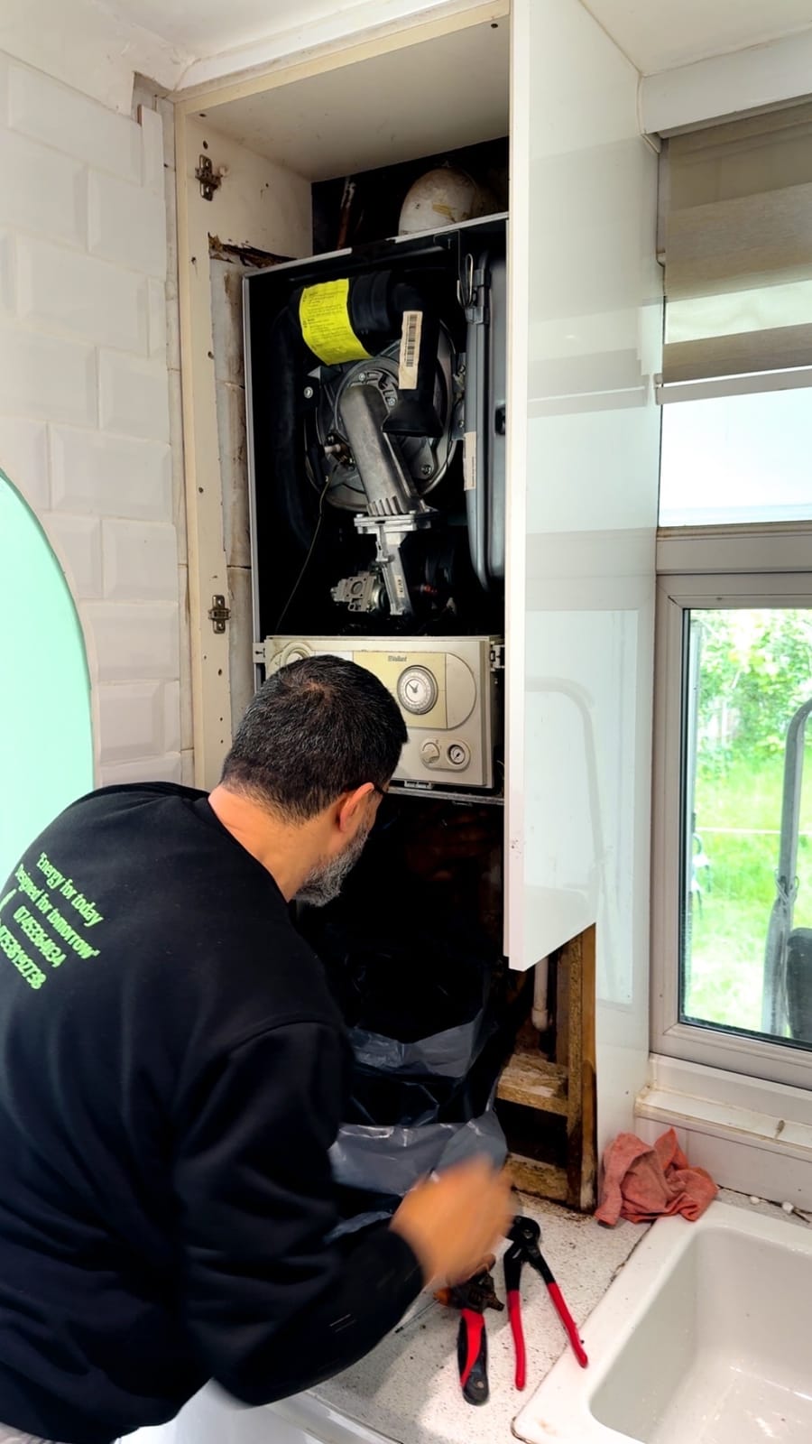 Gas Safe engineer servicing an open boiler in a London home