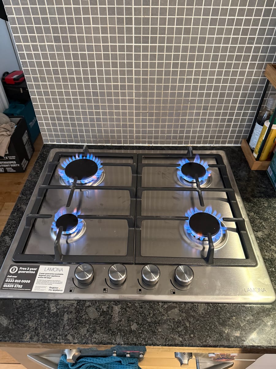 All four burners lit on a gas hob during an appliance safety check