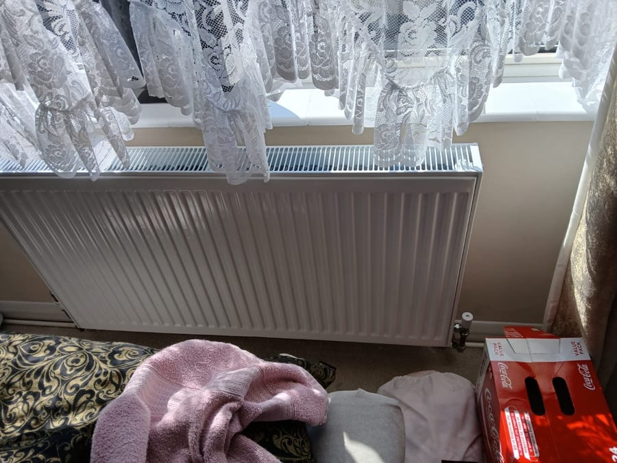 Radiator being fitted in a London home with dust sheets down